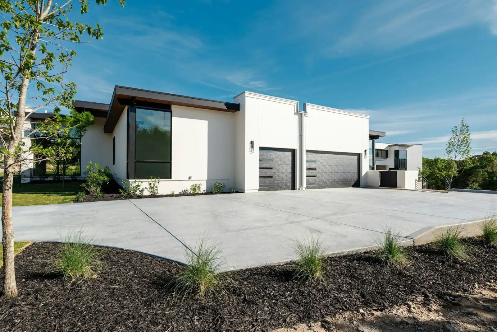 Freshly sealed concrete driveway alongside a wood fence in Arizona