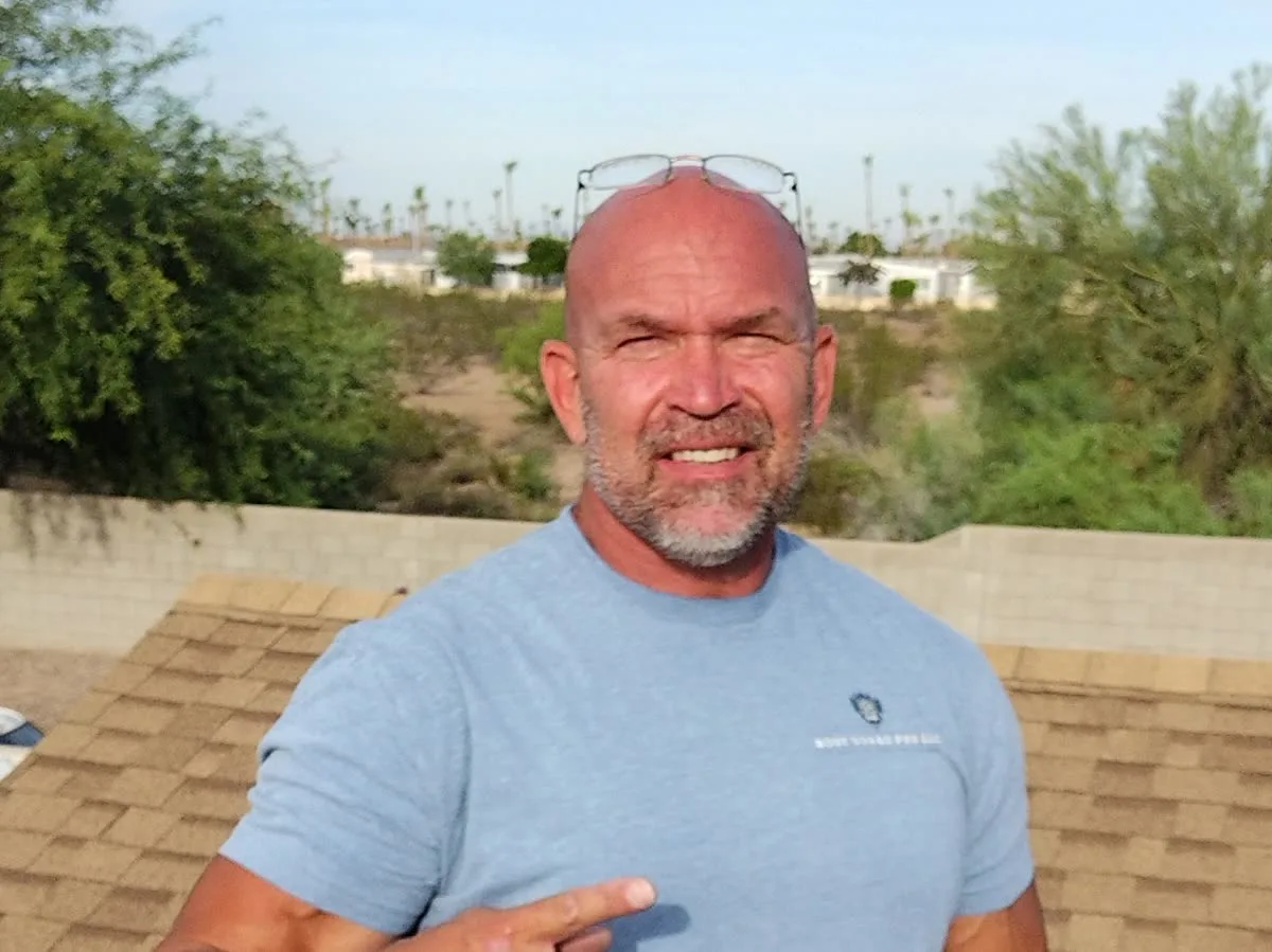 Steve Zweig, owner of Roof Guard Pro, on an Arizona shingle roof in his company shirt